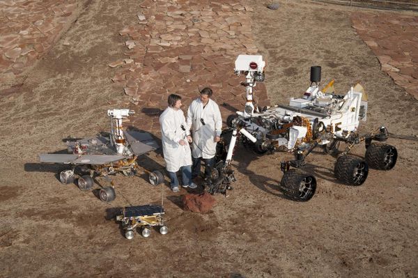 Two spacecraft engineers stand with three generations of Mars rovers developed at NASA JPL, Pasadena, Ca. Front and center is a flight spare of Sojourner, left is a working sibling to Spirit and Opportunity, right is test rover Curiosity. Two spacecraft engineers stand with three generations of Mars rovers developed at NASA JPL, Pasadena, Ca. Front and center is a flight spare of Sojourner, left is a working sibling to Spirit and Opportunity, right is test rover Curiosity. - Sputnik International