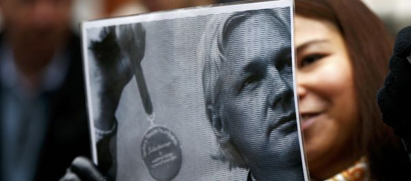 A supporter of Julian Assange holds a poster after prosecutor Ingrid Isgren from Sweden arrived at Ecuador's embassy to interview him in London A supporter of Julian Assange holds a poster after prosecutor Ingrid Isgren from Sweden arrived at Ecuador's embassy to interview him in London - Sputnik International