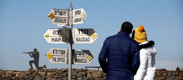 A couple look towards signs pointing out distances to different cities, on Mount Bental, an observation post in the Israeli-occupied Golan Heights that overlooks the Syrian side of the Quneitra crossing, Israel January 21, 2019 A couple look towards signs pointing out distances to different cities, on Mount Bental, an observation post in the Israeli-occupied Golan Heights that overlooks the Syrian side of the Quneitra crossing, Israel January 21, 2019 - Sputnik International