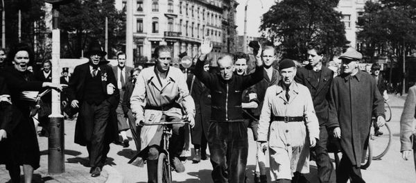 A Belgian collaborator is hustled through the streets of Liege to jail, on Sept. 13, 1944, to save him from being lynched. - Sputnik International