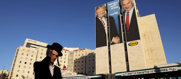 A man walks past a Likud election campaign billboard, depicting U.S. President Donald Trump shaking hands with Israeli Prime Minister Benjamin Netanyahu, in Jerusalem February 4, 2019 - Sputnik International