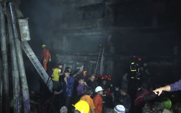 In this image made from a video, firefighters and local people gather near smoldering buildings in Dhaka, Bangladesh Thursday, Feb. 21, 2019. - Sputnik International