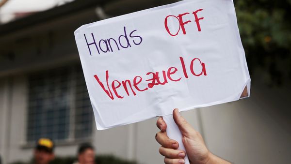 A supporter of Venezuela's President Nicolas Maduro holds a sign after Venezuelan opposition leader Juan Guaido's designated ambassador to Costa Rica Maria Faria took control of Venezuela's embassy, in San Jose, Costa Rica February 20, 2019. - Sputnik International