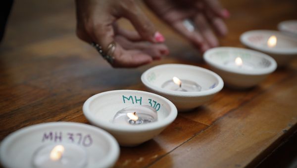 Relative of passengers on board the missing Malaysia Airlines Flight MH370 light up candle during the Day of Remembrance for MH370 event - Sputnik International