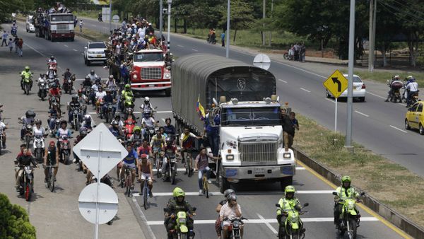 Venezuelans ride atop and alongside semi-trailers accompanying U.S. humanitarian aid destined for Venezuela, in Cucuta, Colombia, Saturday, Feb. 23, 2019 - Sputnik International