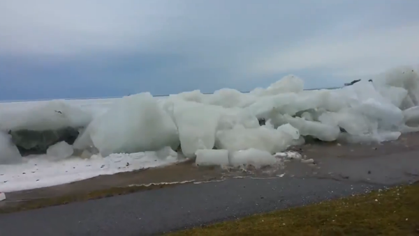 'Ice Tsunami' makes its way past a retaining wall and onto a roadway in Fort Erie, Canada. - Sputnik International