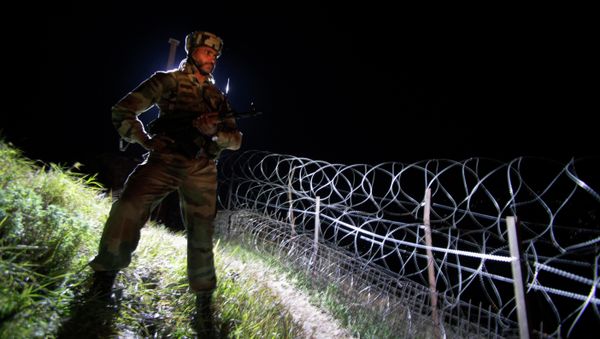 In this Dec. 22, 2013 photo, an Indian army soldier stands guard along barbed wire near the Line of Control (LOC), that divides Kashmir between India and Pakistan, at Krishna Ghati (KG Sector) in Poonch, 290 kilometers (180 miles) from Jammu, India - Sputnik International