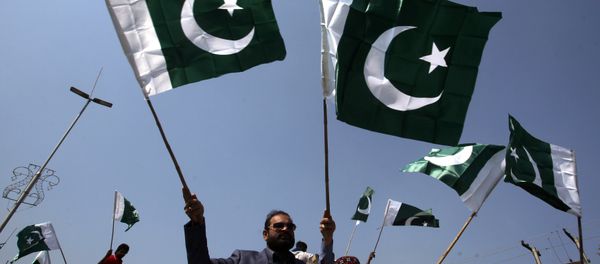 People carry national flags as they celebrate, after Pakistan shot down two Indian military aircrafts, in Lahore, Pakistan February 27, 2019 - Sputnik International