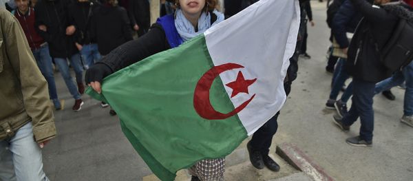 A woman holds an Algerian flag during demonstrations against President Bouteflika in Algiers on 26 February - Sputnik International