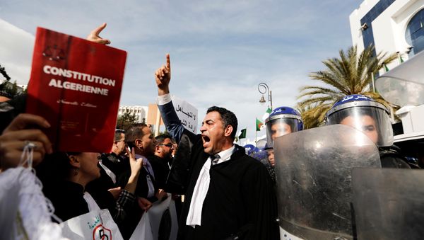 Lawyers chant slogans as they gesture near riot police outside the constitutional council during a protest denouncing an offer by President Abdelaziz Bouteflika to run in elections next month but not to serve a full term if re-elected, in Algiers, Algeria March 7, 2019. - Sputnik International