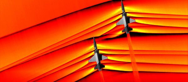 Using the schlieren photography technique, NASA was able to capture the first air-to-air images of the interaction of shockwaves from two supersonic aircraft flying in formation. These two U.S. Air Force Test Pilot School T-38 aircraft are flying in formation, approximately 30 feet apart, at supersonic speeds, or faster than the speed of sound, producing shockwaves that are typically heard on the ground as a sonic boom. The images, originally monochromatic and shown here as colorized composite images, were captured during a supersonic flight series flown, in part, to better understand how shocks interact with aircraft plumes, as well as with each other. Using the schlieren photography technique, NASA was able to capture the first air-to-air images of the interaction of shockwaves from two supersonic aircraft flying in formation. These two U.S. Air Force Test Pilot School T-38 aircraft are flying in formation, approximately 30 feet apart, at supersonic speeds, or faster than the speed of sound, producing shockwaves that are typically heard on the ground as a sonic boom. The images, originally monochromatic and shown here as colorized composite images, were captured during a supersonic flight series flown, in part, to better understand how shocks interact with aircraft plumes, as well as with each other. - Sputnik International