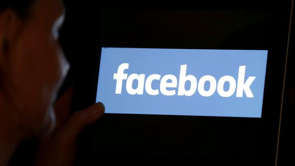 A woman looks at the Facebook logo on an iPad in this photo illustration taken June 3, 2018 - Sputnik International