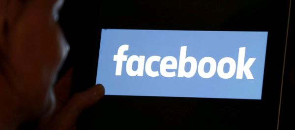 A woman looks at the Facebook logo on an iPad in this photo illustration taken June 3, 2018 - Sputnik International