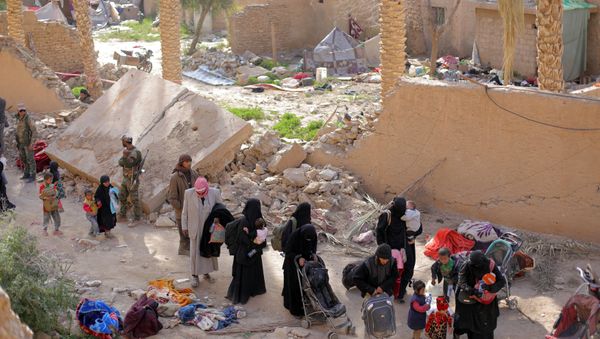 Islamic state fighters and their families walk as they surrendered in the village of Baghouz, Deir Al Zor province, Syria March 12, 2019 - Sputnik International