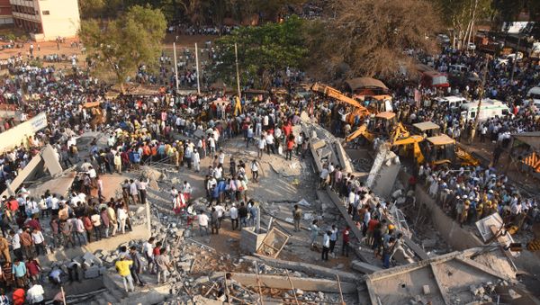 Onlookers gather near the rubble while rescue team search for survivors after an under-construction multi-storey building collapsed in Dharwad district of Karnataka - Sputnik International