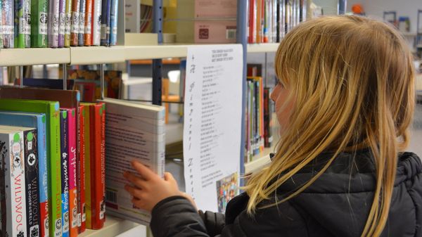 A young girl picking up a book - Sputnik International