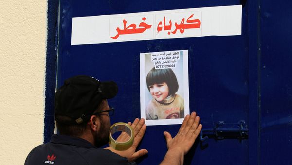 A man attaches a picture of a missing child on a door, after a ferry sank in the Tigris river, outside a morgue in Mosul, Iraq March 22, 2019. - Sputnik International