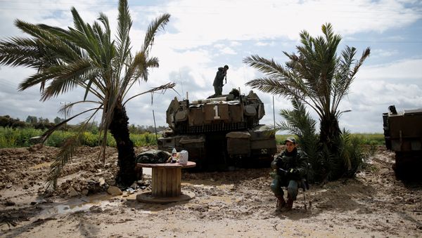 An Israeli soldier stands atop a tank near the border with Gaza, in southern Israel March 25, 2019 - Sputnik International