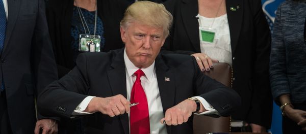 US President Donald Trump takes the cap off a pen to sign an executive order to start the Mexico border wall project at the Department of Homeland Security facility in Washington, DC, on January 25, 2017.  - Sputnik International