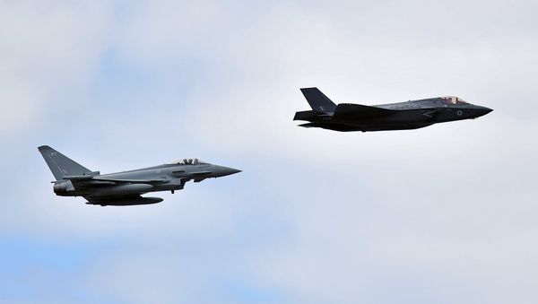 A British Royal Air Force (RAF) Lockheed Martin F-35 Lightning II (R) and a Eurofighter Typhoon aircraft perform a fly-past during the Farnborough Airshow, south west of London, on July 17, 2018 - Sputnik International