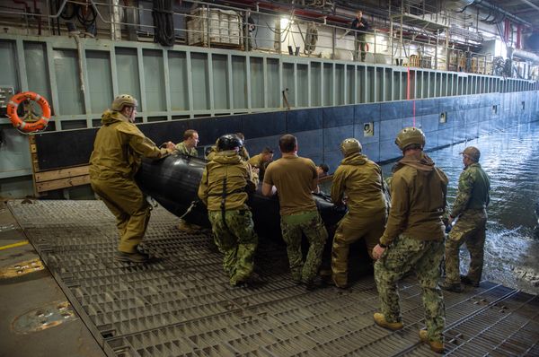 Sailors assigned to Explosive Ordnance Disposal Mobile Unit 2 prepare to launch a combat rubber raiding craft from the well deck of the Royal Fleet Auxiliary landing ship dock Mounts Bay during a mine countermeasures (MCM) task group experiment.  - Sputnik International