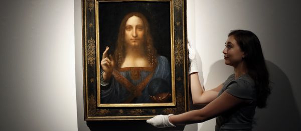 In this Oct. 24, 2017 file photo, an employee poses with Leonardo da Vinci's Salvator Mundi on display at Christie's auction rooms in London. - Sputnik International