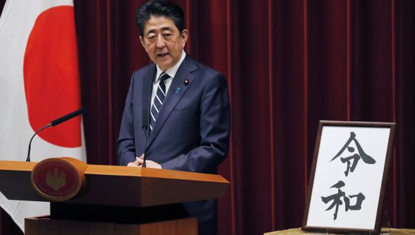 Japanese Prime Minister Shinzo Abe stands beside the Japanese characters of kanji which make up Reiwa, the new imperial era - Sputnik International