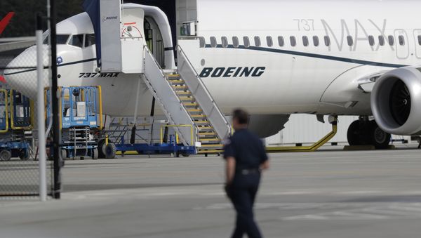 A worker walks next to a Boeing 737 MAX 8 airplane parked at Boeing Field, Thursday, March 14, 2019, in Seattle A worker walks next to a Boeing 737 MAX 8 airplane parked at Boeing Field, Thursday, March 14, 2019, in Seattle - Sputnik International