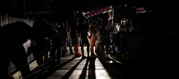 Locals gather at a street food cart during a blackout in Caracas, Venezuela March 29, 2019 - Sputnik International