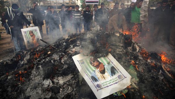 Libyan protesters burn a poster of Libyan leader Moammar Gadhafi as it is burned during a demonstration against him in Benghazi, eastern Libya, Wednesday, March 2 , 2011 Libyan protesters burn a poster of Libyan leader Moammar Gadhafi as it is burned during a demonstration against him in Benghazi, eastern Libya, Wednesday, March 2 , 2011 - Sputnik International