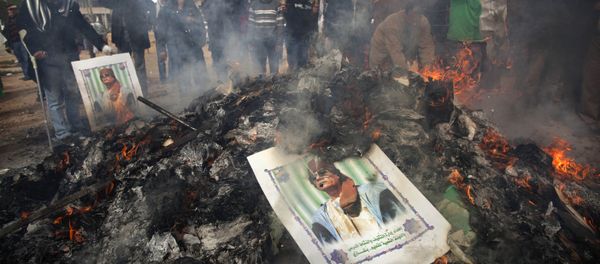 Libyan protesters burn a poster of Libyan leader Moammar Gadhafi as it is burned during a demonstration against him in Benghazi, eastern Libya, Wednesday, March 2 , 2011 Libyan protesters burn a poster of Libyan leader Moammar Gadhafi as it is burned during a demonstration against him in Benghazi, eastern Libya, Wednesday, March 2 , 2011 - Sputnik International