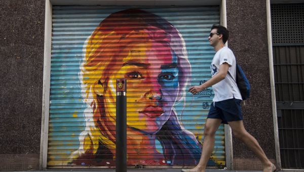 A man walks in front of a graffiti by street artist Axe Colours portraying British actress Emilia Clarke known for playing Daenerys Targaryen in The Game of Thrones TV series in Barcelona on July 30, 2017 A man walks in front of a graffiti by street artist Axe Colours portraying British actress Emilia Clarke known for playing Daenerys Targaryen in The Game of Thrones TV series in Barcelona on July 30, 2017 - Sputnik International