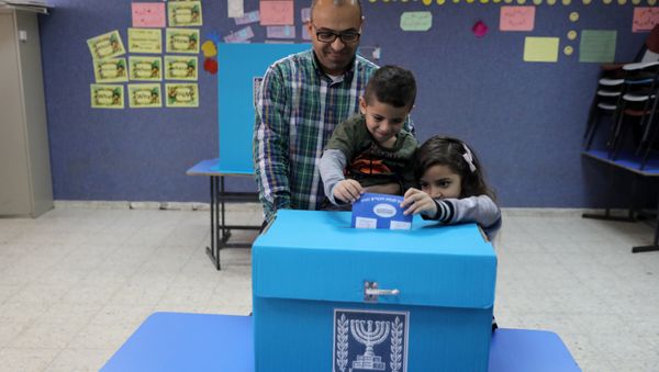 An Israeli-Arab father casts a ballot together with his children, as Israelis vote in a parliamentary election, at a polling station in Umm al-Fahm, Israel - Sputnik International