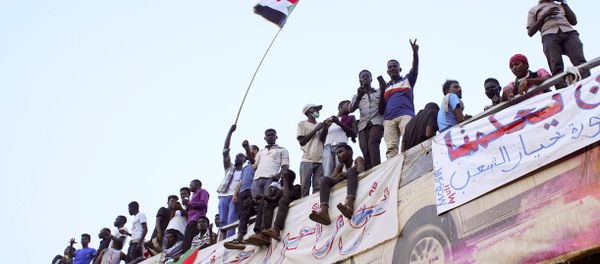 Demonstrators wave their national flag as they attend a protest rally demanding Sudanese President Omar Al-Bashir to step down outside Defence Ministry in Khartoum, Sudan April 10, 2019. Demonstrators wave their national flag as they attend a protest rally demanding Sudanese President Omar Al-Bashir to step down outside Defence Ministry in Khartoum, Sudan April 10, 2019. - Sputnik International