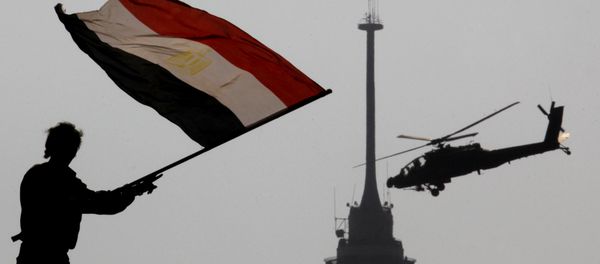 An opponent of Egypt's ousted president Mohammed Morsi waves a national flag as a military helicopter flies over Tahrir Square in Cairo, Egypt, Friday, July 5, 2013 An opponent of Egypt's ousted president Mohammed Morsi waves a national flag as a military helicopter flies over Tahrir Square in Cairo, Egypt, Friday, July 5, 2013 - Sputnik International