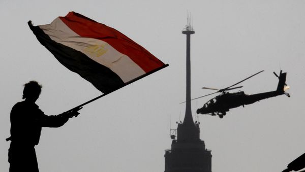 An opponent of Egypt's ousted president Mohammed Morsi waves a national flag as a military helicopter flies over Tahrir Square in Cairo, Egypt, Friday, July 5, 2013 An opponent of Egypt's ousted president Mohammed Morsi waves a national flag as a military helicopter flies over Tahrir Square in Cairo, Egypt, Friday, July 5, 2013 - Sputnik International