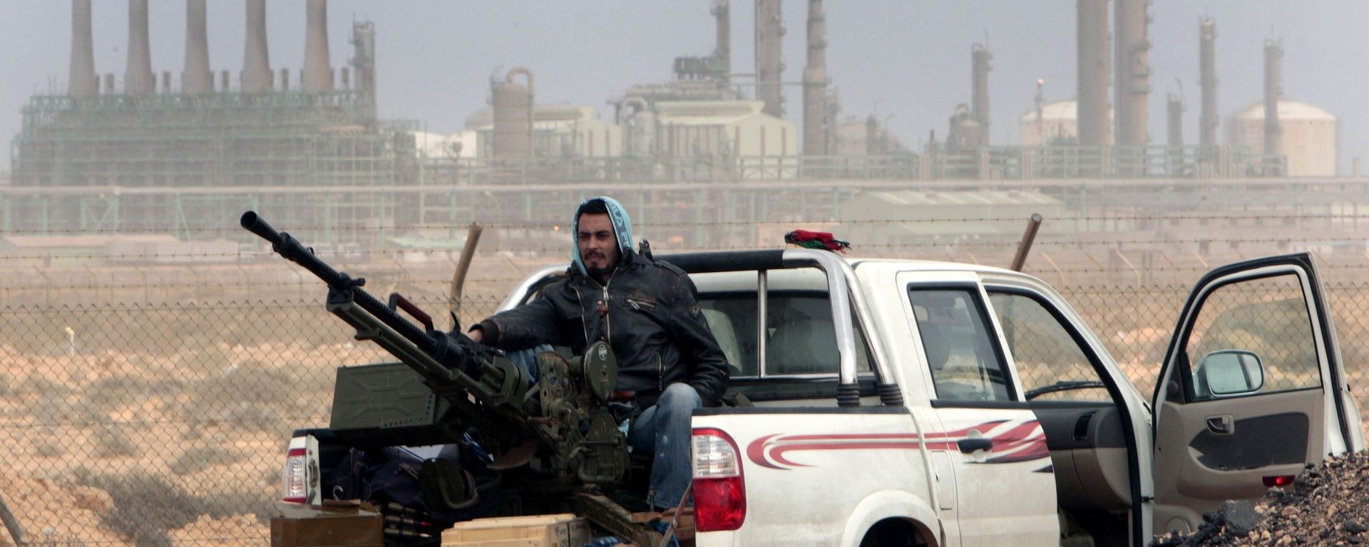 An anti-government rebel sits with an anti-aircraft weapon in front an oil refinery in Ras Lanouf, eastern Libya. An anti-government rebel sits with an anti-aircraft weapon in front an oil refinery in Ras Lanouf, eastern Libya. - Sputnik International, 1920, 28.08.2022