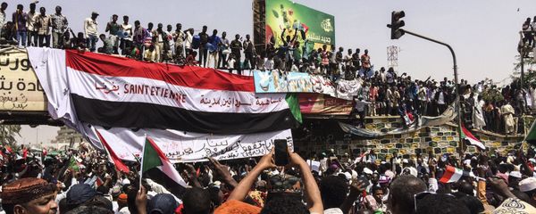 Demonstrators gather in Sudan's capital of Khartoum, Friday, April 12, 2019. The Sudanese protest movement has rejected the military's declaration that it has no ambitions to hold the reins of power for long after ousting the president of 30 years, Omar al-Bashir. The writing on the Sudanese flag says 'With the participation of the Sudanese in Saint Etienne, France.' Demonstrators gather in Sudan's capital of Khartoum, Friday, April 12, 2019. The Sudanese protest movement has rejected the military's declaration that it has no ambitions to hold the reins of power for long after ousting the president of 30 years, Omar al-Bashir. The writing on the Sudanese flag says 'With the participation of the Sudanese in Saint Etienne, France.' - Sputnik International