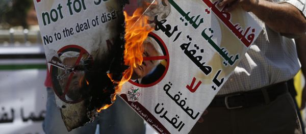 Palestinians burn portraits of US President Donald Trump during a demonstration in the West Bank city of Ramallah against US policy supporting Israel on July 2, 2018 - Sputnik International