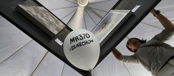 A man arranges artwork for an exhibition marking the Day of Remembrance for MH370 event in Kuala Lumpur, Malaysia on Saturday, March 4, 2017 A man arranges artwork for an exhibition marking the Day of Remembrance for MH370 event in Kuala Lumpur, Malaysia on Saturday, March 4, 2017 - Sputnik International