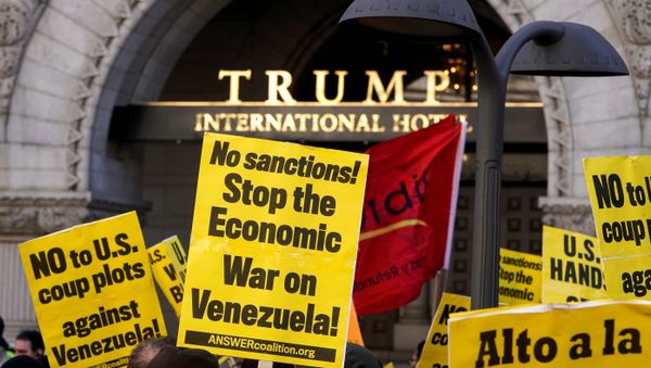 Activists hold up signs during a Hands Off Venezuela as they march past the Trump International Hotel in Washington, U.S., March 16, 2019 - Sputnik International
