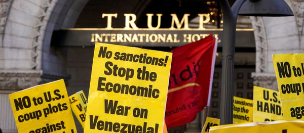 Activists hold up signs during a Hands Off Venezuela as they march past the Trump International Hotel in Washington, U.S., March 16, 2019 Activists hold up signs during a Hands Off Venezuela as they march past the Trump International Hotel in Washington, U.S., March 16, 2019 - Sputnik International