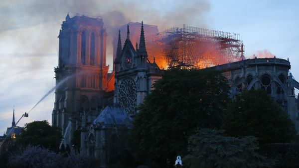 A firefighter tackles the blaze as flames and smoke rise from Notre Dame cathedral as it burns in Paris, Monday, April 15, 2019. Massive plumes of yellow brown smoke is filling the air above Notre Dame Cathedral and ash is falling on tourists and others around the island that marks the center of Paris - Sputnik International