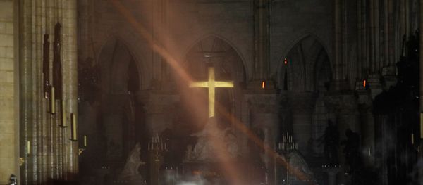 Smoke rises around the alter in front of the cross inside the Notre Dame Cathedral as a fire continues to burn in Paris, France, April 16, 2019. - Sputnik International