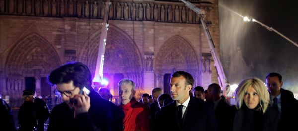 French President Emmanuel Macron and his wife Brigitte walk outside the Notre Dame Cathedral where a fire continues to burn in Paris on April 16, 2019. French President Emmanuel Macron and his wife Brigitte walk outside the Notre Dame Cathedral where a fire continues to burn in Paris on April 16, 2019. - Sputnik International