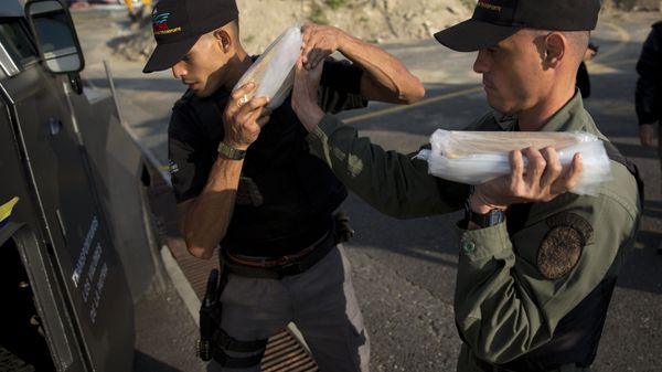 Members of a military agency that transports valuables put gold bars into an armored vehicle to be taken to Venezuela's Central Bank, at the Carlota military airport in Caracas, Venezuela, Thursday, March 1, 2018 - Sputnik International