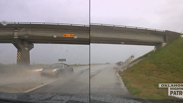 US Teen Hydroplanes in Sports Car, Almost Strikes Highway Patrol Officer - Sputnik International
