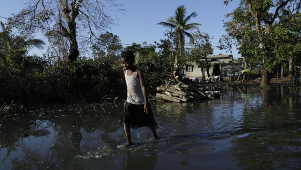 a young girl walks through flood waters near Beira, Mozambique, March 26, 2019, in one of the world's areas most vulnerable to global warming's rising waters - Sputnik International