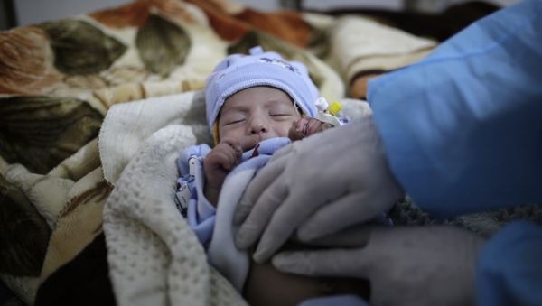 a doctor checks a two-month-old infant suffering from a cholera infection, at Al-Sabeen hospital, in Sanaa, Yemen, on March 30, 2019 - Sputnik International