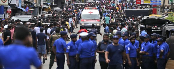 Sri Lankan police officers clear the road as an ambulance drives through carrying injured of Church blasts in Colombo, Sri Lanka, Sunday, April 21, 2019. A Sri Lanka hospital spokesman says several blasts on Easter Sunday have killed dozens of people. Sri Lankan police officers clear the road as an ambulance drives through carrying injured of Church blasts in Colombo, Sri Lanka, Sunday, April 21, 2019. A Sri Lanka hospital spokesman says several blasts on Easter Sunday have killed dozens of people. - Sputnik International